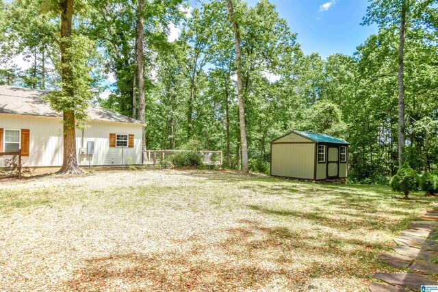 view of grassy yard featuring a storage shed and an outbuilding