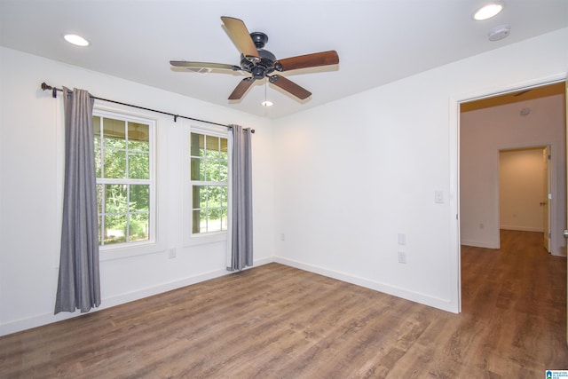 spare room featuring a smoke detector, wood finished floors, recessed lighting, ceiling fan, and baseboards