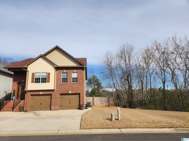 view of home's exterior with driveway, a garage, fence, and brick siding