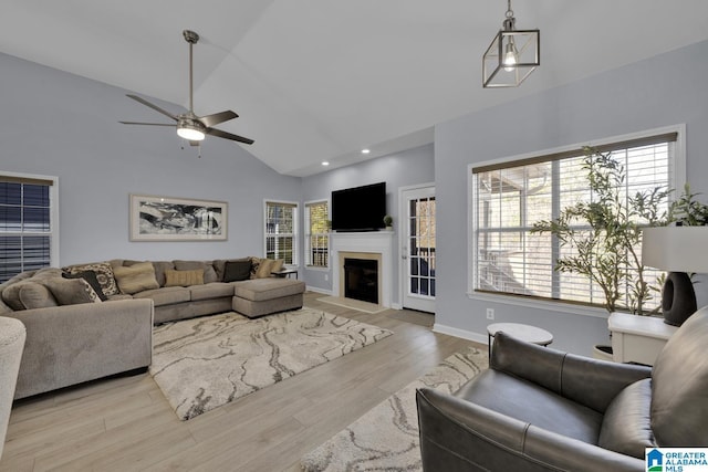 living room with ceiling fan, recessed lighting, a fireplace with flush hearth, baseboards, and light wood-type flooring