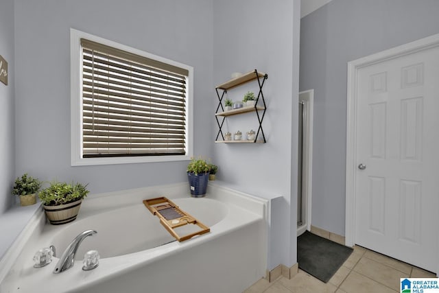 bathroom with a garden tub and tile patterned floors