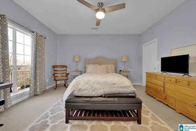 bedroom with a ceiling fan, visible vents, light carpet, and baseboards