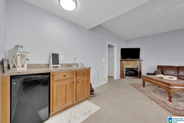 kitchen with light colored carpet, open floor plan, light countertops, fridge, and a sink