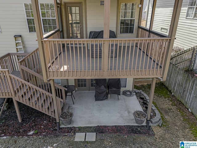 deck with stairs, a patio, and fence