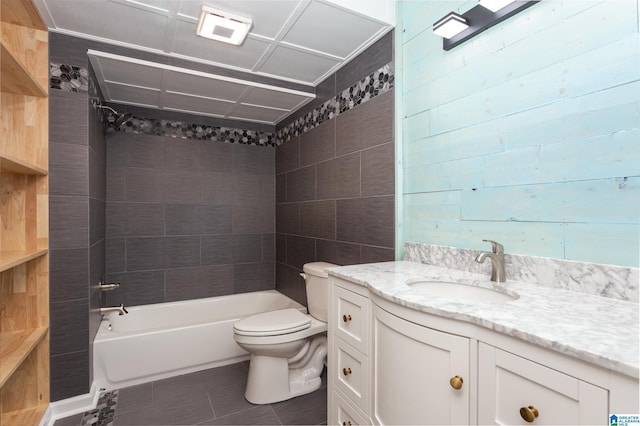 full bathroom with tiled shower / bath combo, toilet, tile patterned floors, and vanity