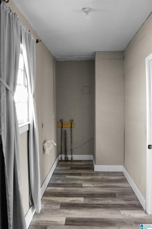 laundry area featuring baseboards and wood finished floors