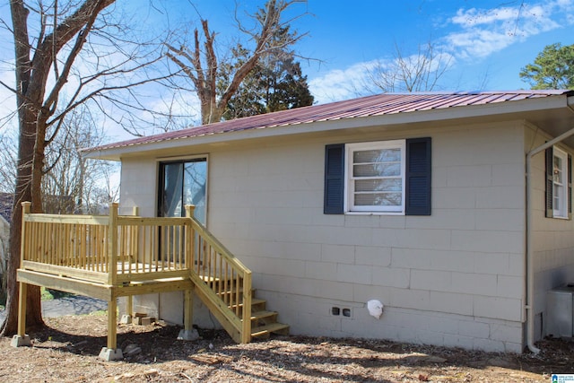 exterior space with crawl space, metal roof, and a deck