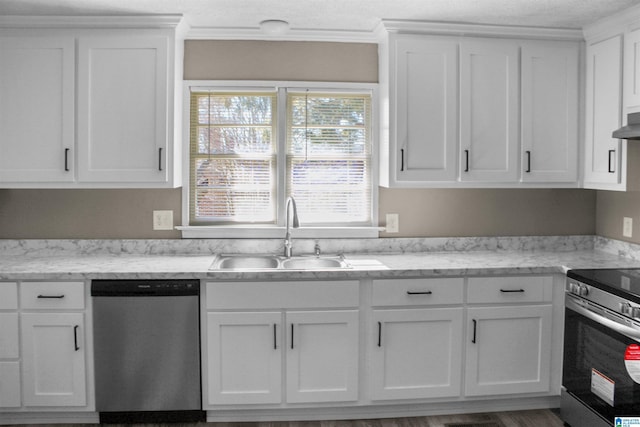 kitchen with range hood, appliances with stainless steel finishes, white cabinets, a sink, and light stone countertops