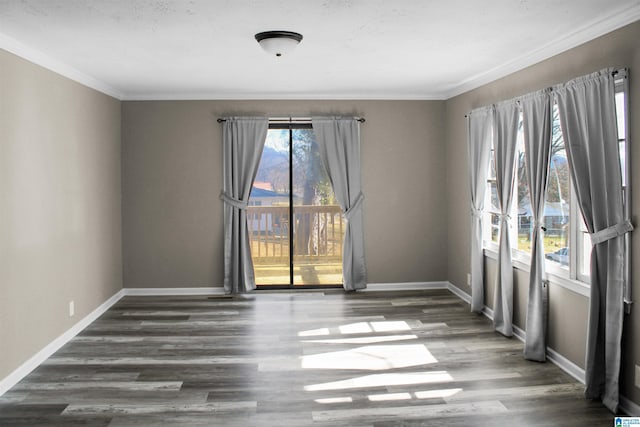 spare room featuring baseboards, wood finished floors, and ornamental molding