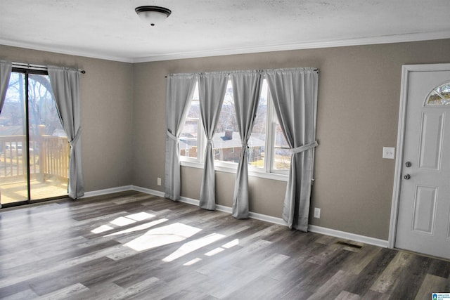interior space with baseboards, wood finished floors, and a healthy amount of sunlight