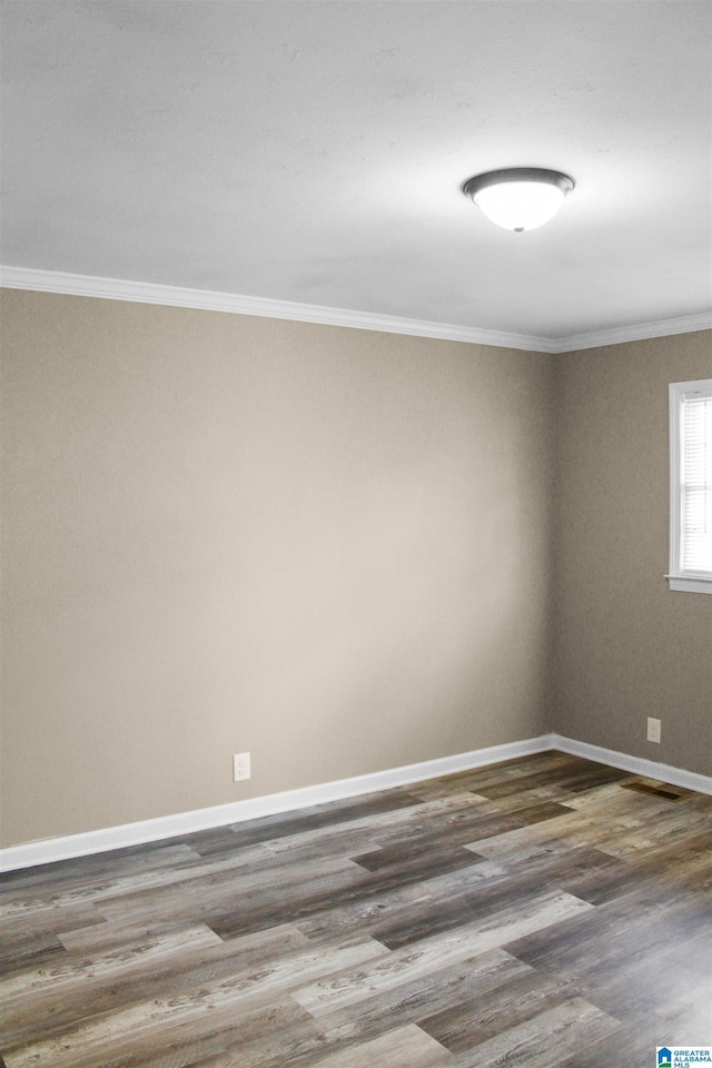 unfurnished room featuring crown molding, baseboards, and wood finished floors