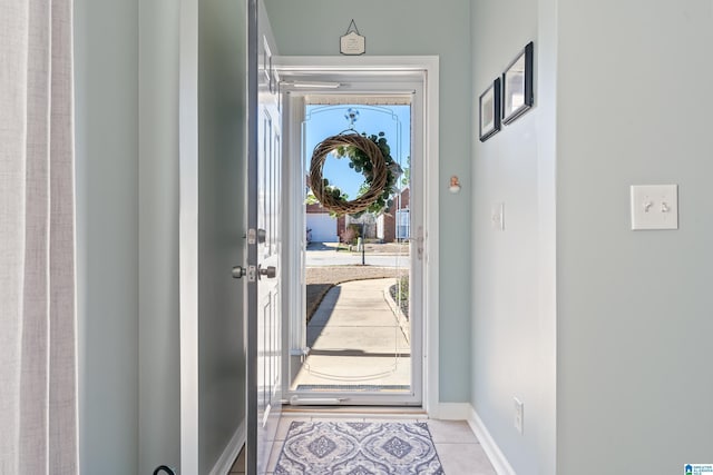 doorway featuring light tile patterned floors and baseboards