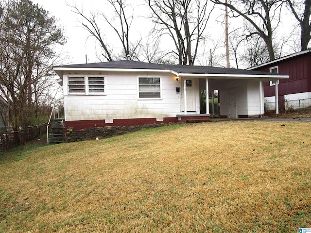 ranch-style home featuring a front lawn and a carport