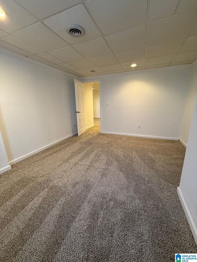 unfurnished room featuring a paneled ceiling, baseboards, visible vents, and carpet flooring