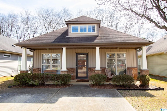 view of front of property featuring a porch, board and batten siding, and brick siding