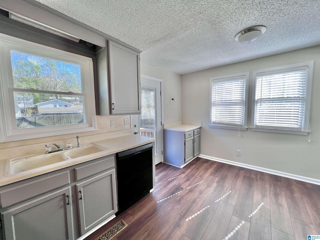 kitchen featuring black dishwasher, sink, gray cabinets, a textured ceiling, and dark hardwood / wood-style floors