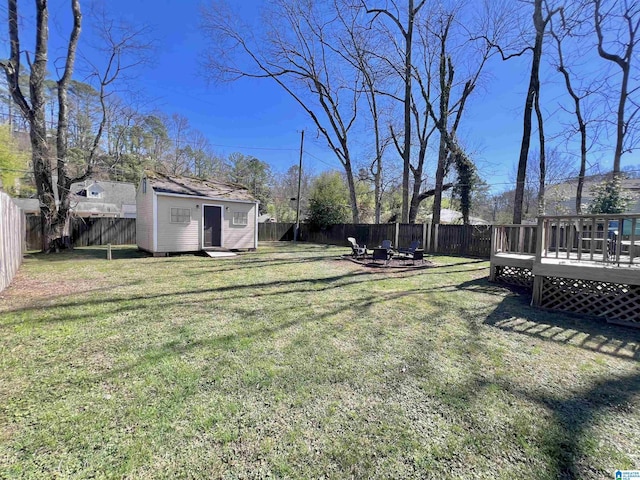 view of yard featuring a deck and a storage unit