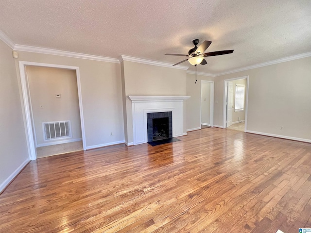 unfurnished living room with a brick fireplace, ceiling fan, wood-type flooring, and ornamental molding