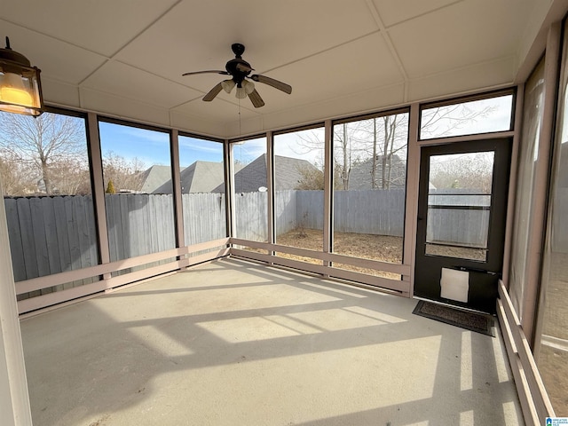 unfurnished sunroom featuring a ceiling fan