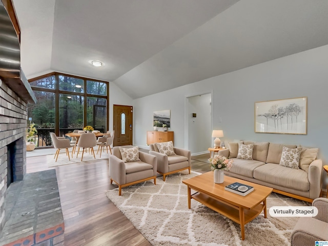 living room with lofted ceiling, hardwood / wood-style flooring, and a fireplace