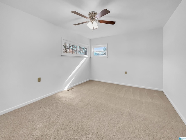 empty room with a ceiling fan, baseboards, visible vents, and carpet flooring