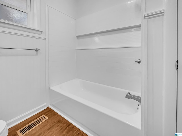 full bathroom featuring bathtub / shower combination, visible vents, and wood finished floors