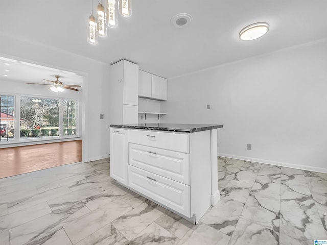 kitchen with marble finish floor, dark countertops, decorative light fixtures, and white cabinets