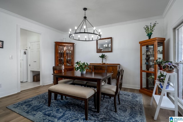 dining room featuring crown molding, baseboards, and wood finished floors