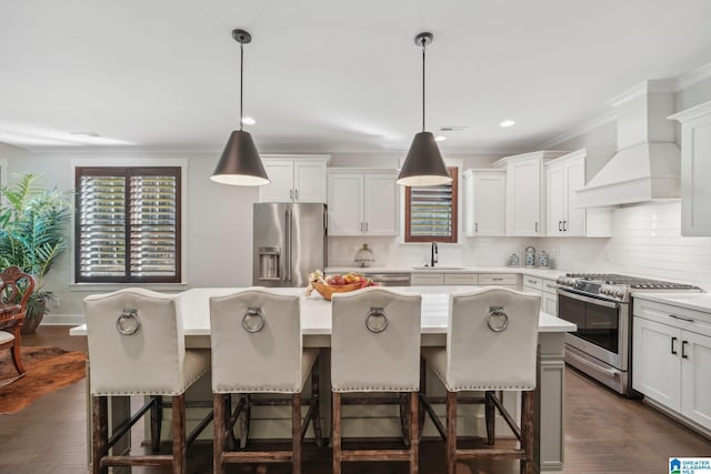 kitchen featuring appliances with stainless steel finishes, sink, hanging light fixtures, and a center island