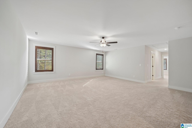 empty room featuring ceiling fan and light carpet