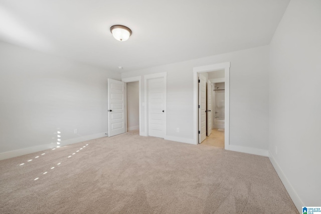 unfurnished bedroom with light colored carpet and ensuite bathroom