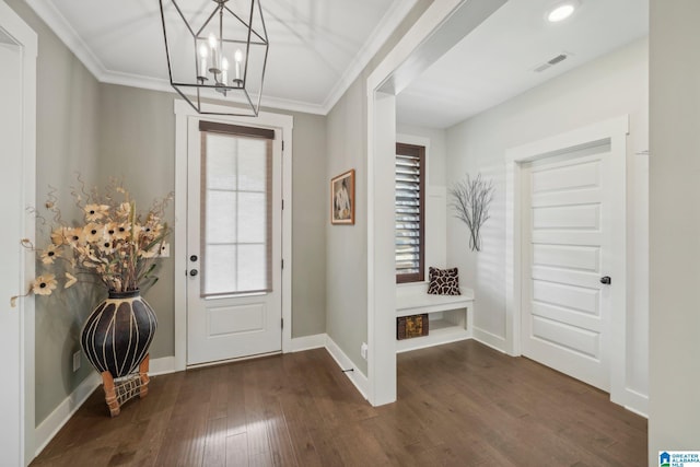 entrance foyer with ornamental molding, a chandelier, dark hardwood / wood-style floors, and plenty of natural light