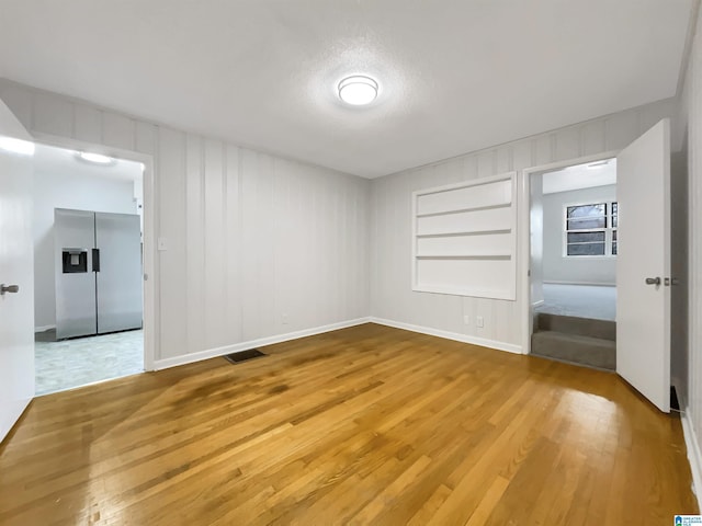 unfurnished room with wood-type flooring