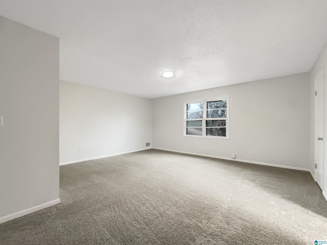 unfurnished room featuring dark colored carpet and a textured ceiling