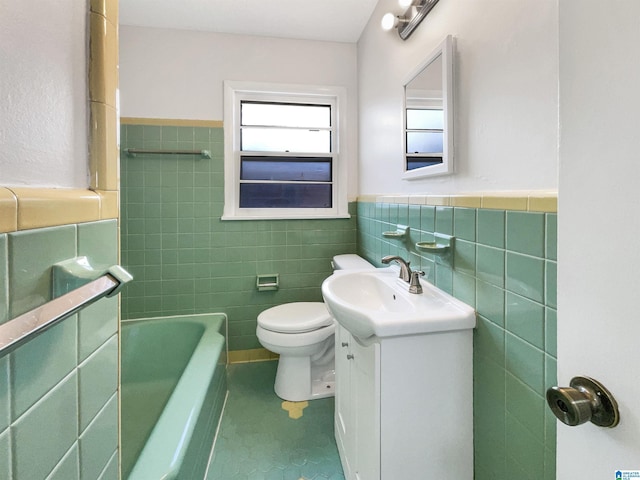 bathroom with tile walls, vanity, a washtub, and toilet