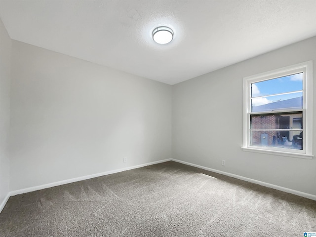 carpeted spare room featuring a textured ceiling