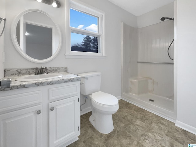 bathroom featuring vanity, toilet, and walk in shower