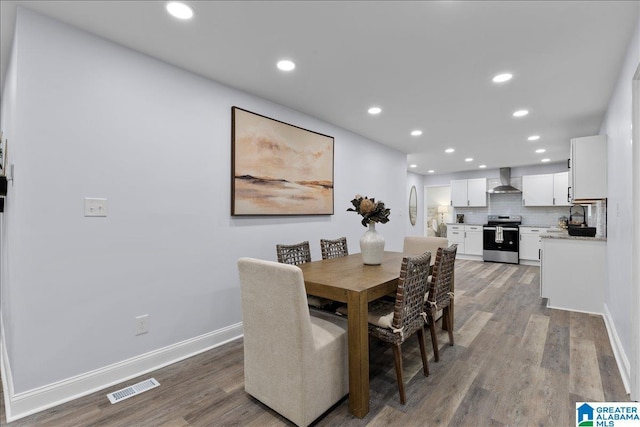 dining space featuring sink and dark wood-type flooring