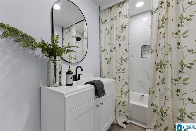 bathroom featuring hardwood / wood-style flooring, vanity, and shower / bath combo with shower curtain