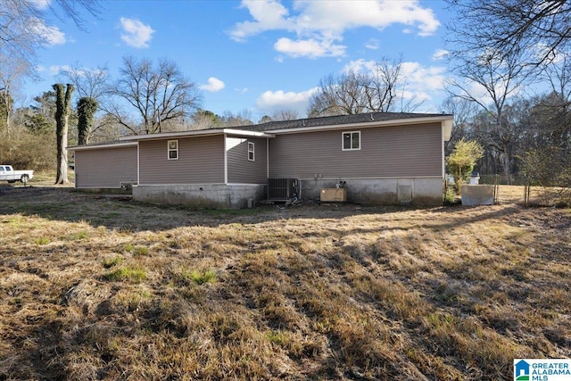 rear view of property with cooling unit and a yard