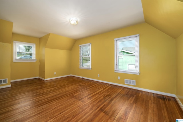 bonus room with hardwood / wood-style floors and vaulted ceiling