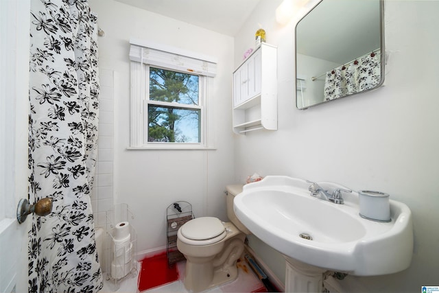 bathroom featuring sink, toilet, and a shower with curtain