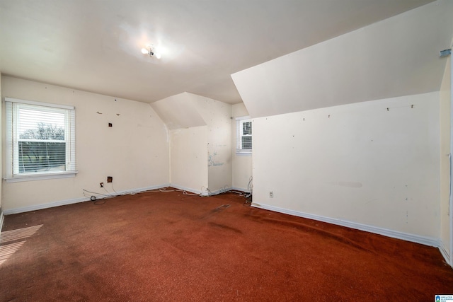 bonus room featuring vaulted ceiling and carpet