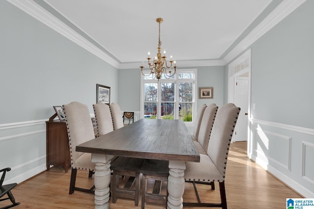 dining area featuring a chandelier, crown molding, and light wood-style floors