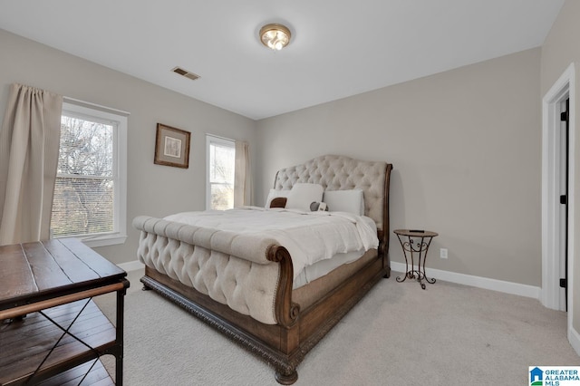 bedroom with light carpet, visible vents, and baseboards