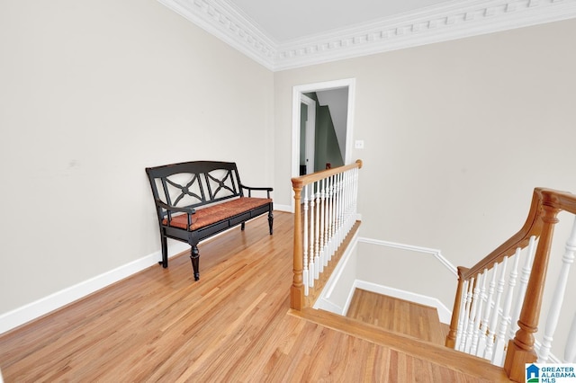 sitting room featuring ornamental molding, light wood finished floors, an upstairs landing, and baseboards