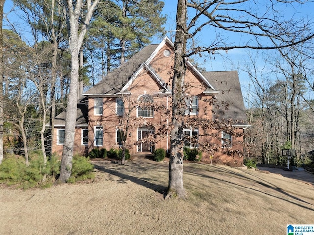 view of front of house with brick siding and a front yard