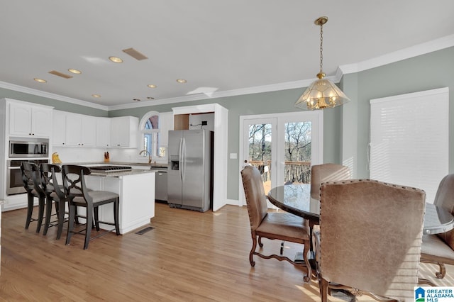 kitchen featuring appliances with stainless steel finishes, a center island, white cabinets, and a healthy amount of sunlight