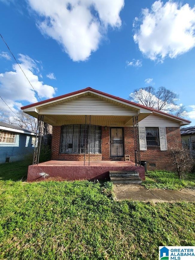 view of front of property featuring covered porch and a front yard