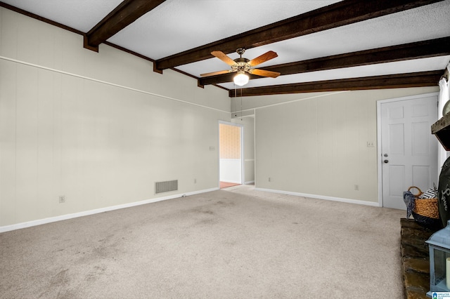 unfurnished living room featuring beam ceiling, ceiling fan, and carpet